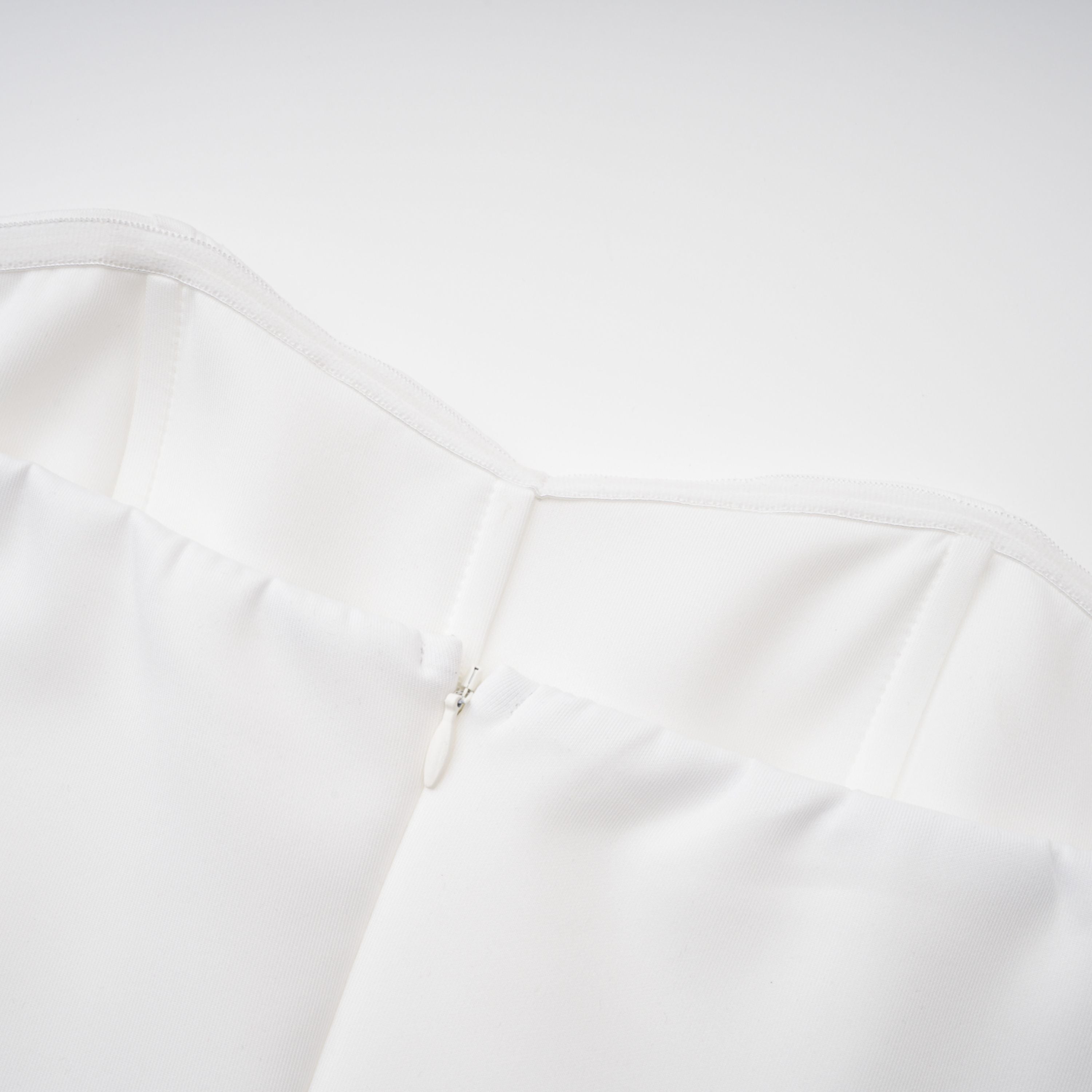 Vestido de novia en conjunto con capa estructurada blanca y corsé, con detalles elegantes y sofisticados.