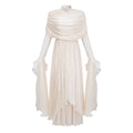 Vestido largo maxi de novia Gustave en tono neutro con volantes y detalles rizados, con capa y estilo elegante.