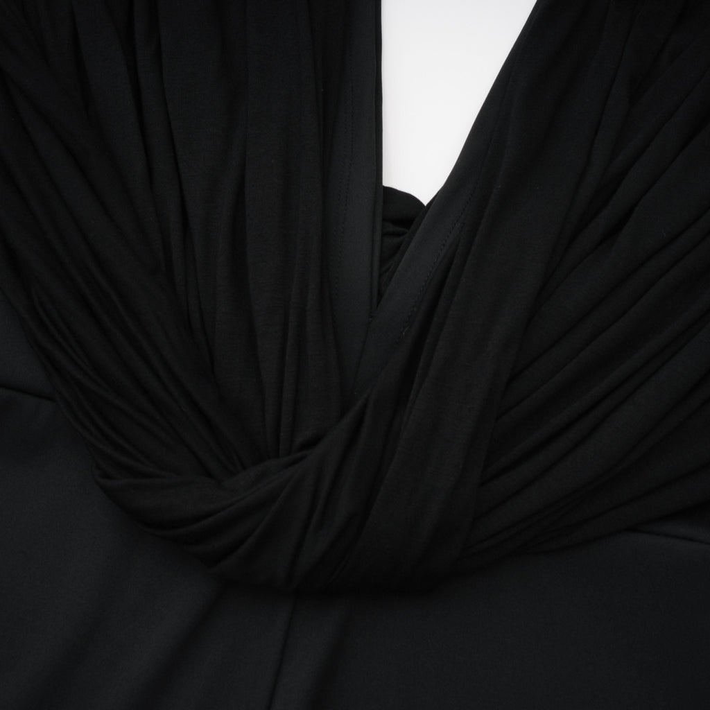 Mono negro Gianina de Bridal con escote en V profundo y drapeado, mostrando su diseño elegante y ajustado en la imagen.
