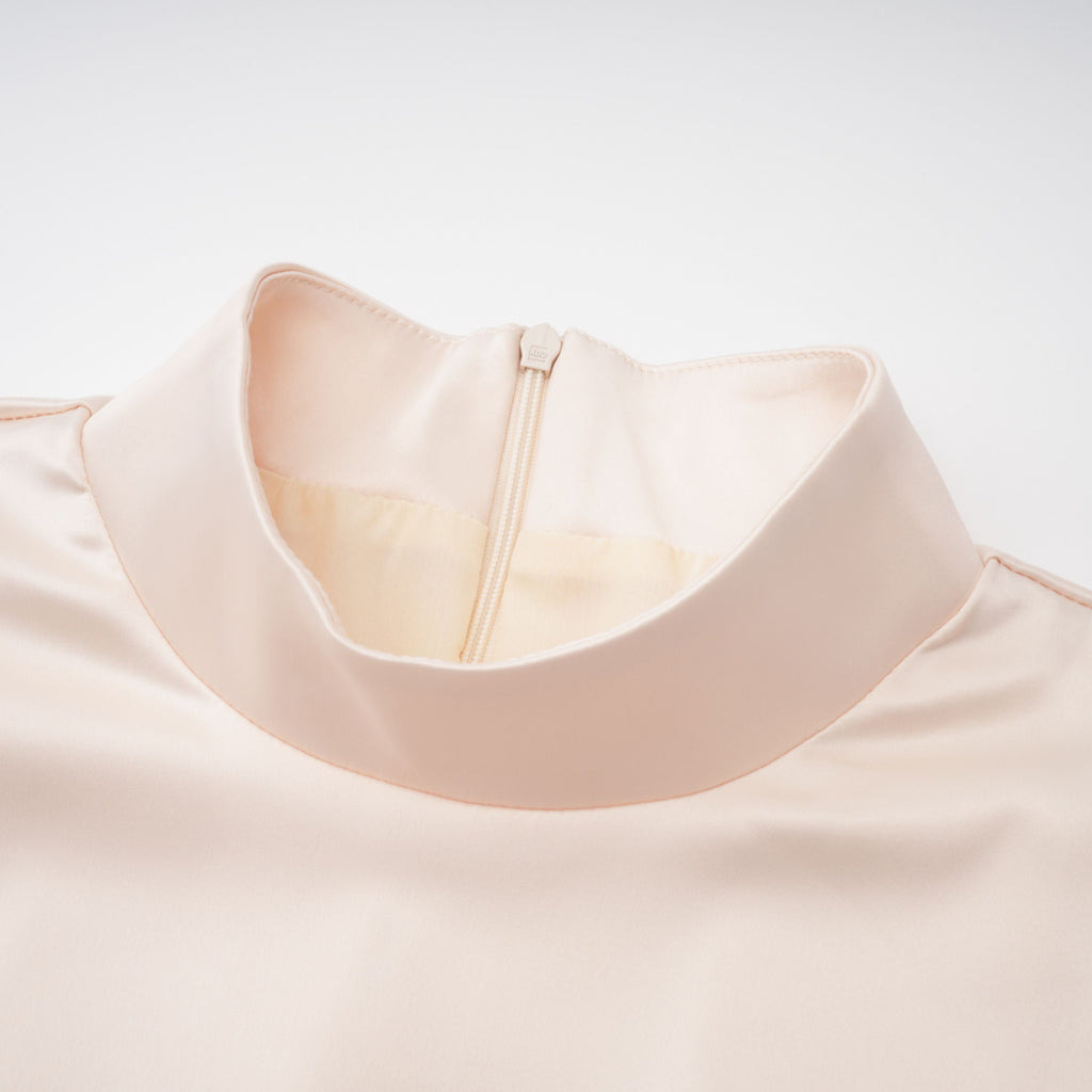 Blusa de cuello alto neutro y falda sirena de la marca Bridal, conjunto elegante y moderno en tonos neutros.