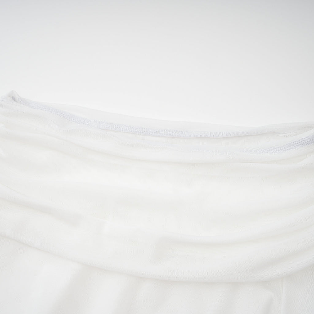 Conjunto de blusa blanca de cuello alto con recortes y falda a juego de la marca Bridal, vista en la imagen.