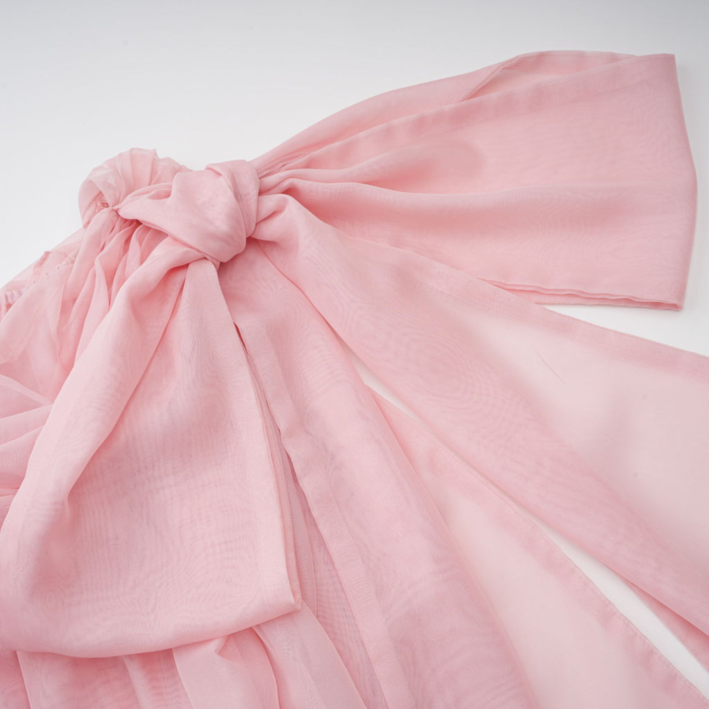 Vestido mini drapeado rosa con lazo Avril, estilo elegante y femenino, con detalles suaves y corte ajustado.