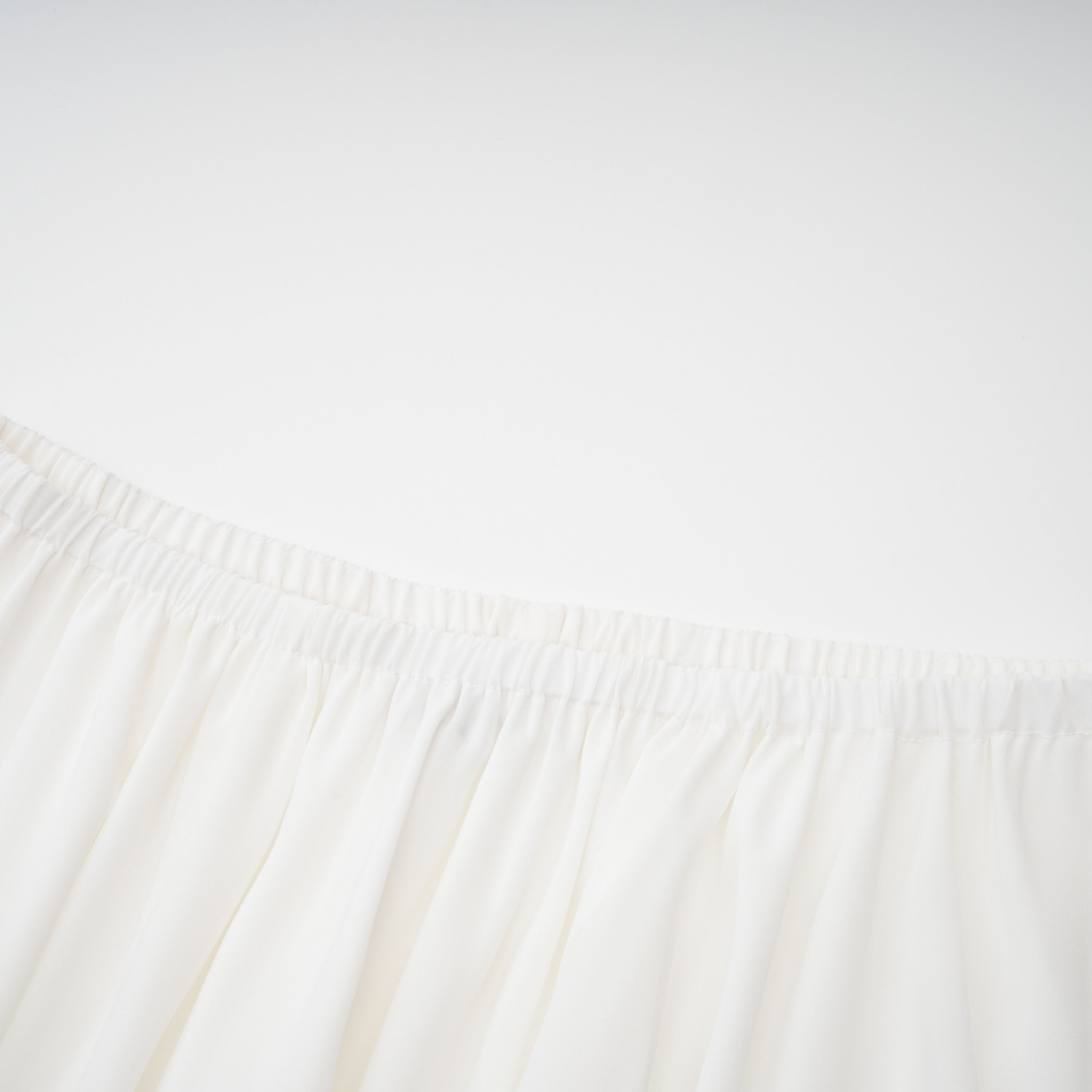Conjunto de vestido y falda blancos con adornos de la marca Bridal, mostrando detalles elegantes y tela delicada.