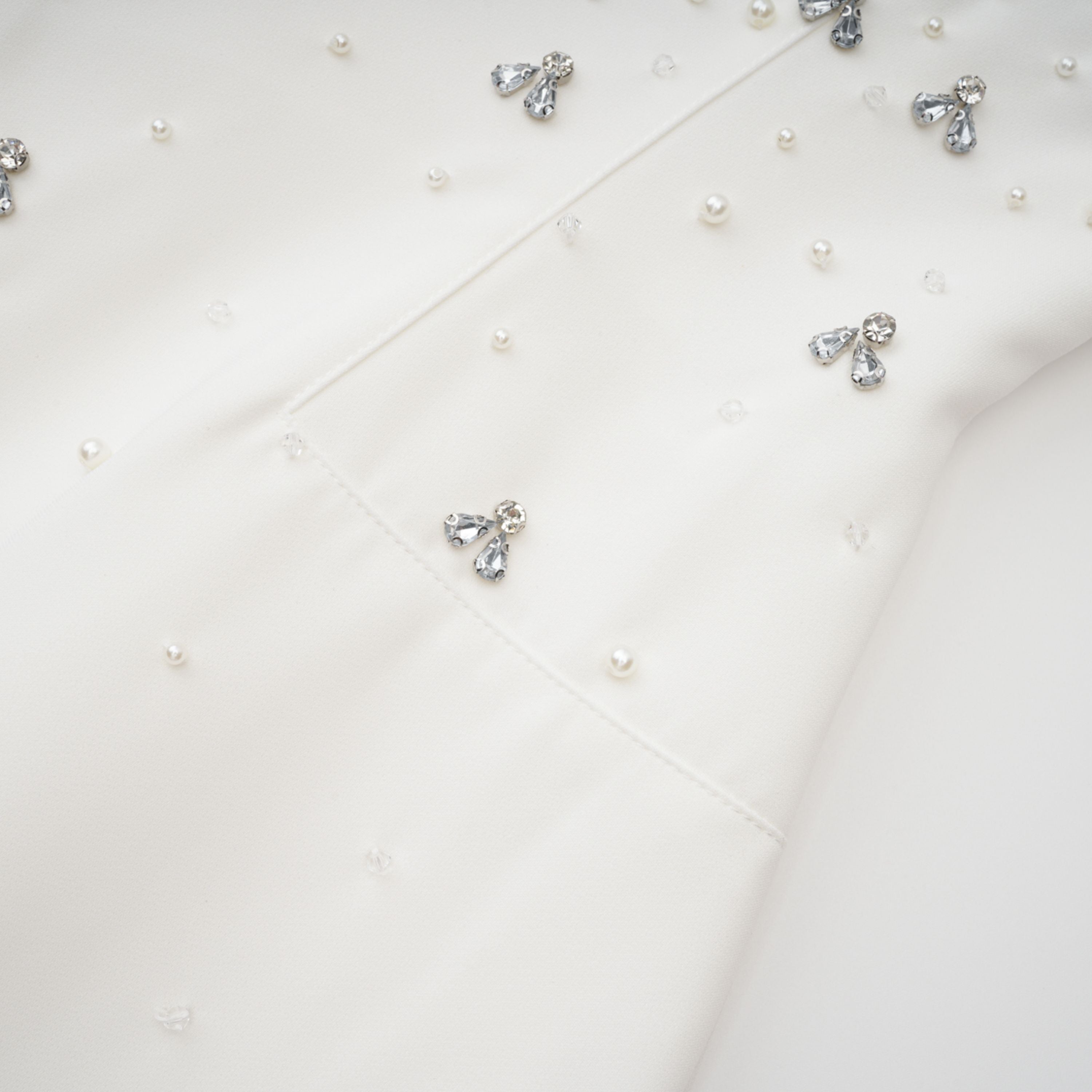 Conjunto de vestido y falda blancos con adornos de la marca Bridal, con detalles elegantes y diseño formal para ocasiones especiales.