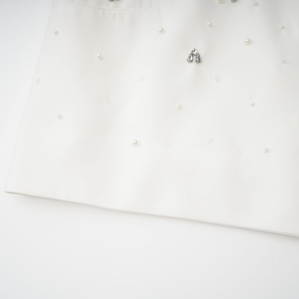 Conjunto de vestido y falda blancos de la marca Bridal con detalles adornados, visible en la imagen.