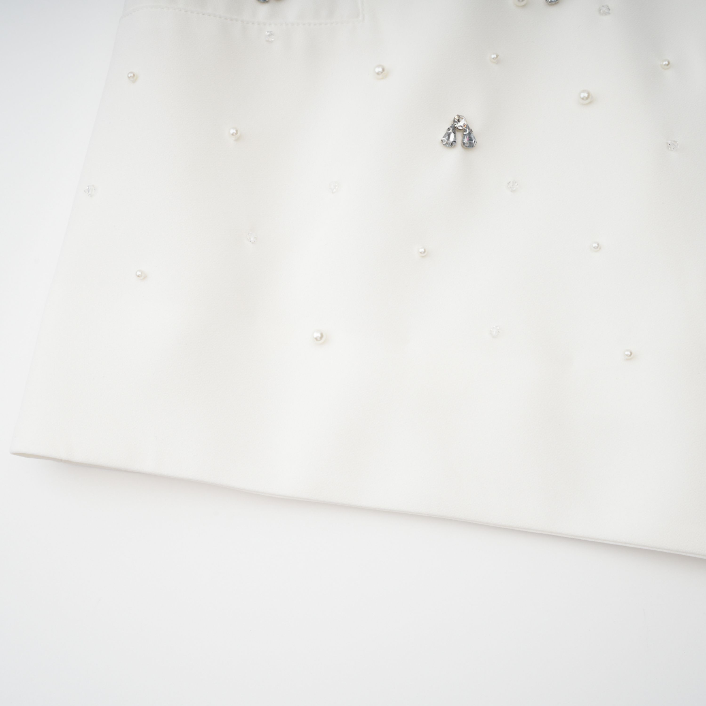 Conjunto de vestido y falda blancos de la marca Bridal con detalles adornados, visible en la imagen.