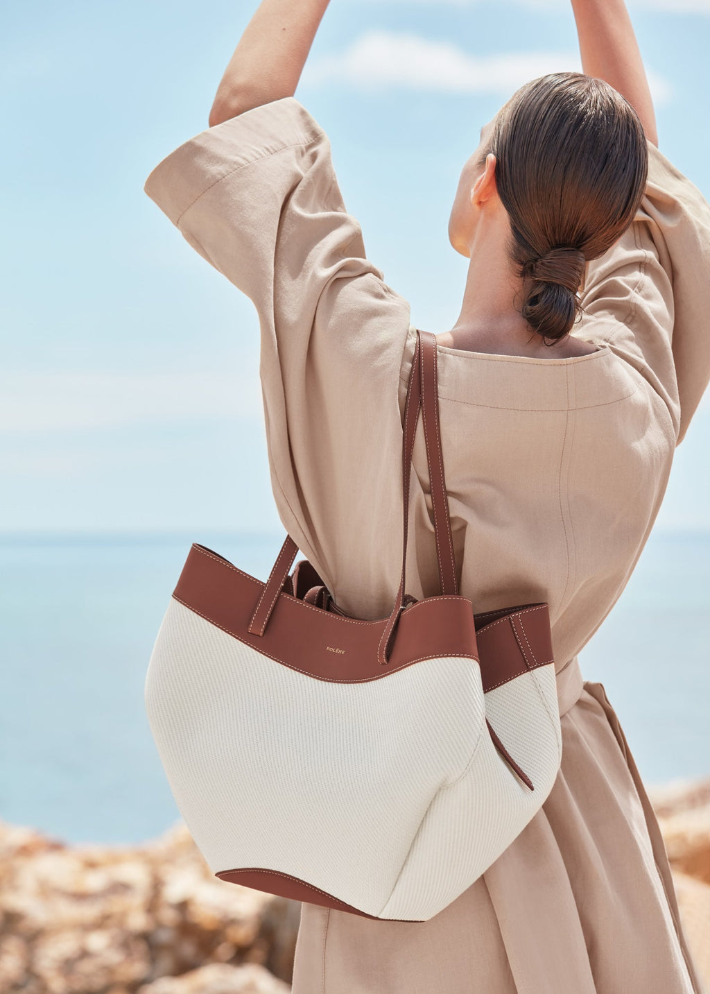 Bolso de mano trenzado Cyme Coñac de Polène, hecho a mano con textura trenzada y diseño elegante en color coñac.