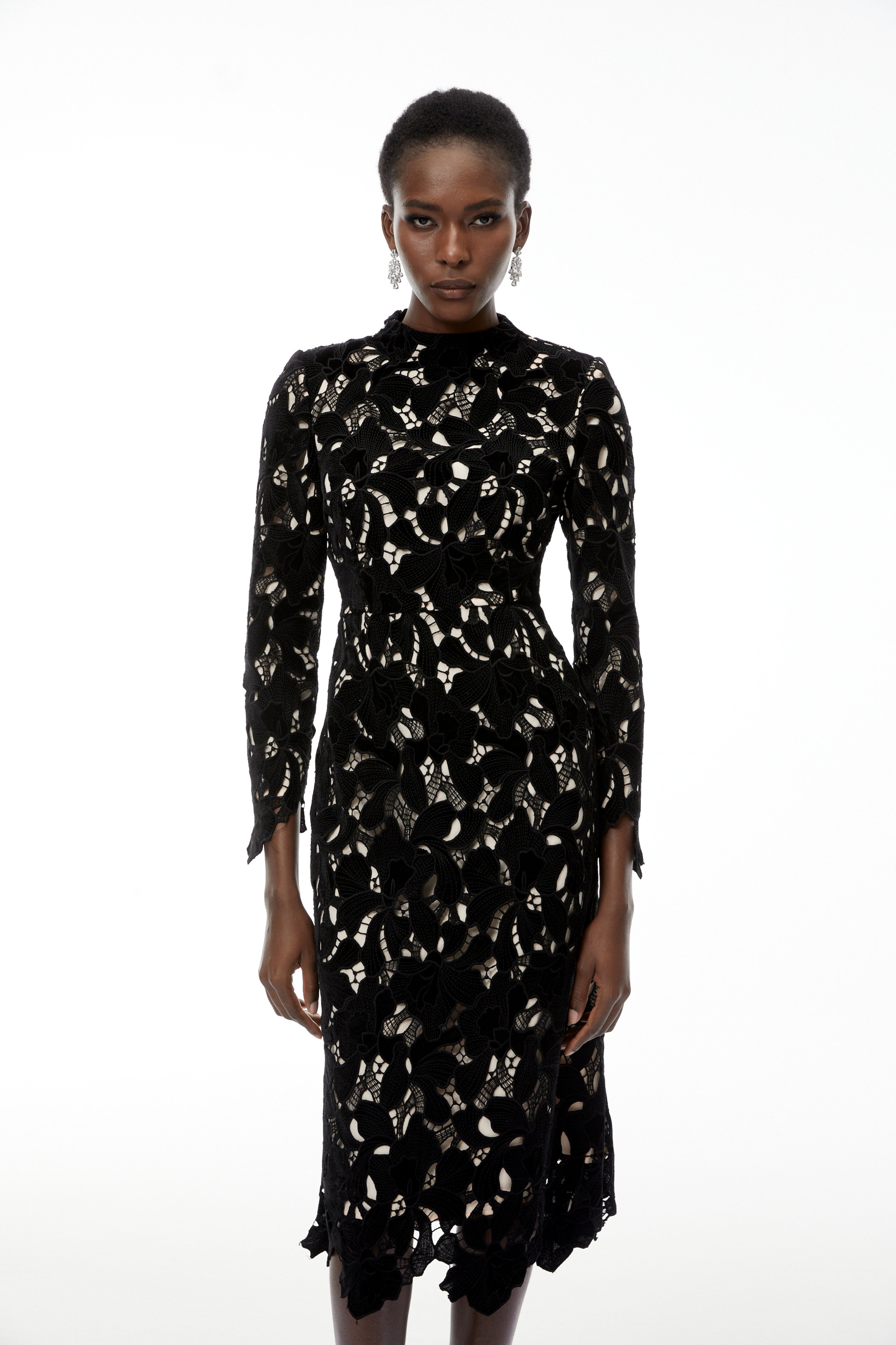 Vestido midi negro con bordado floral y detalles de encaje, de la marca MRMelbourne, vista frontal con corte en la cintura.