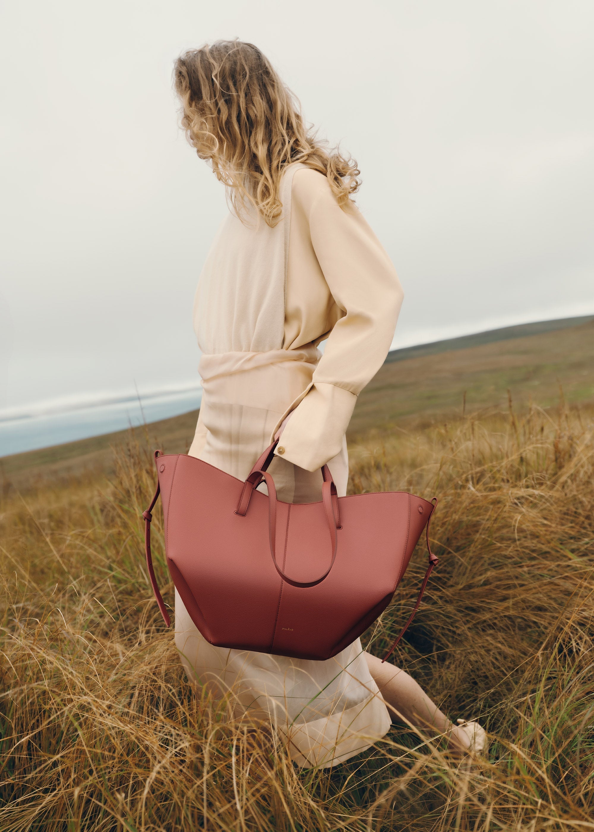 Bolso de mano Polène Cyme en terracota piel granulada, diseño elegante y moderno, con detalles en piel de alta calidad.