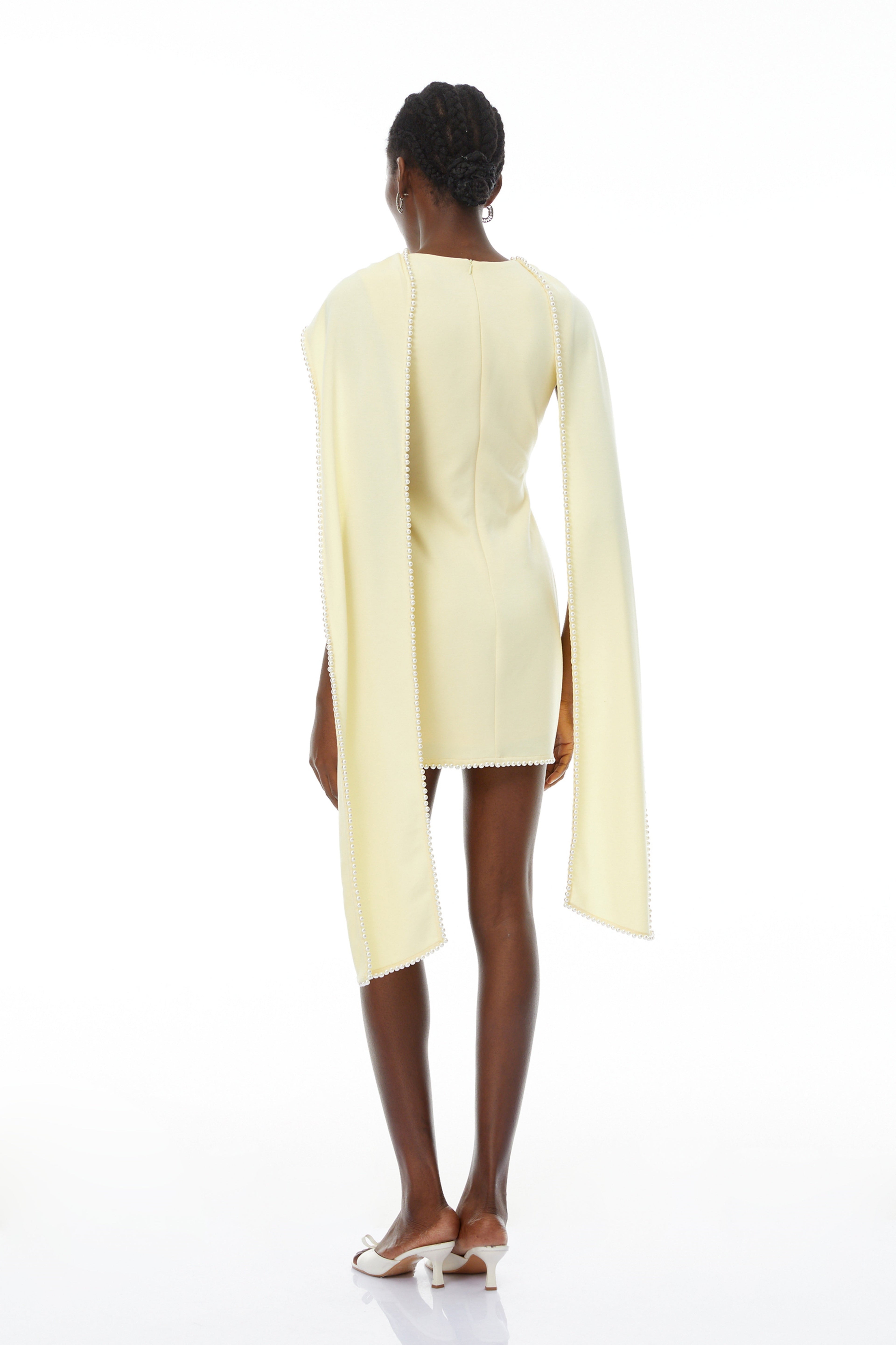 Vestido mini sin mangas amarillo Piroska con borde de perlas, diseñado por Bridal, en estilo elegante y moderno.