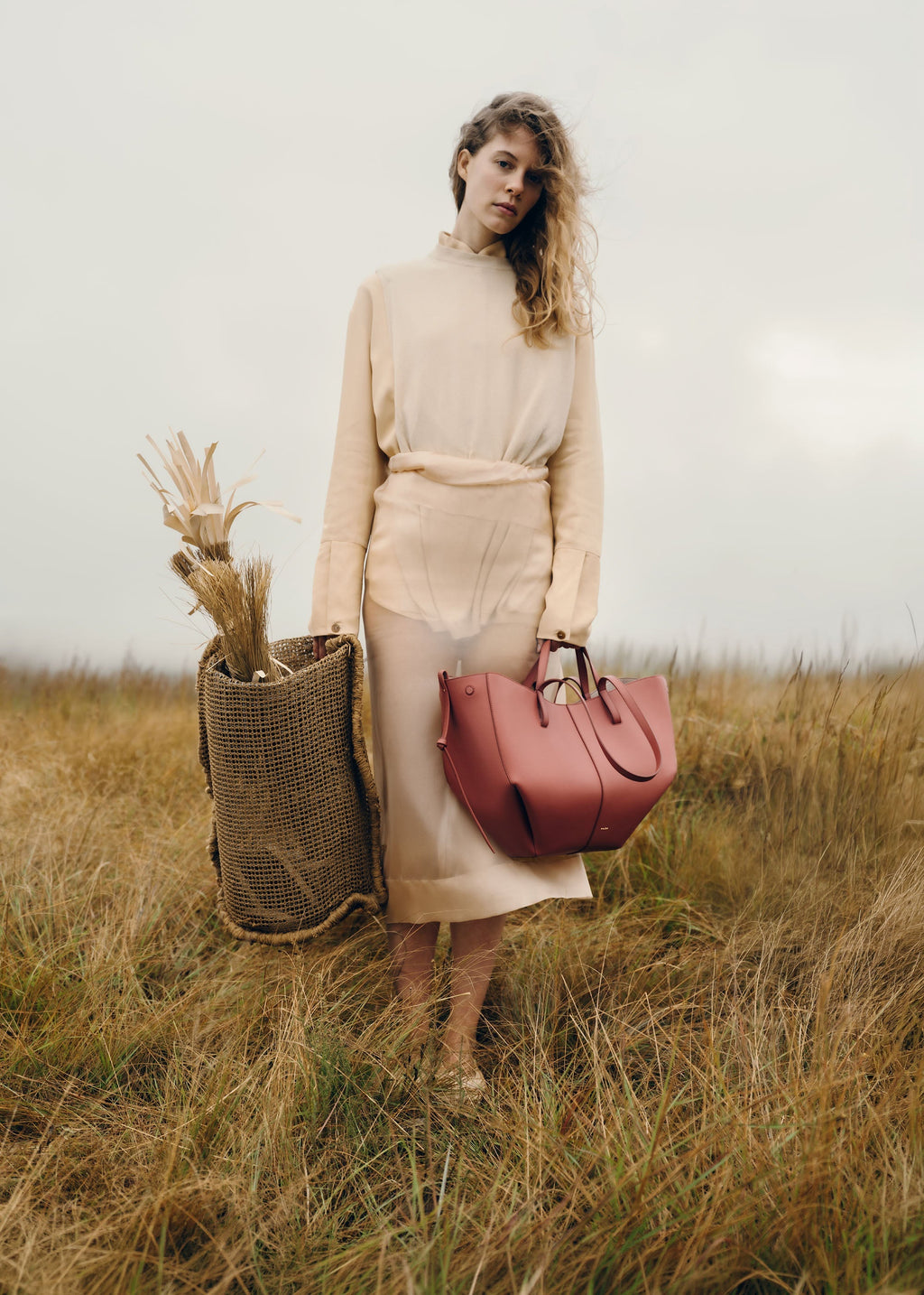 Bolso de mano Polène Cyme en terracota piel granulada, con diseño elegante y detalles texturizados.