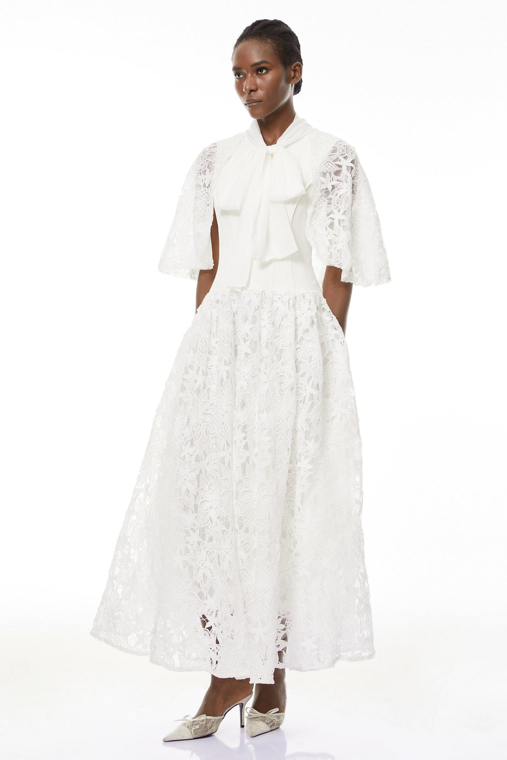 Vestido largo blanco con encaje floral y lazo en el cuello, de la marca MRMelbourne, para eventos elegantes.