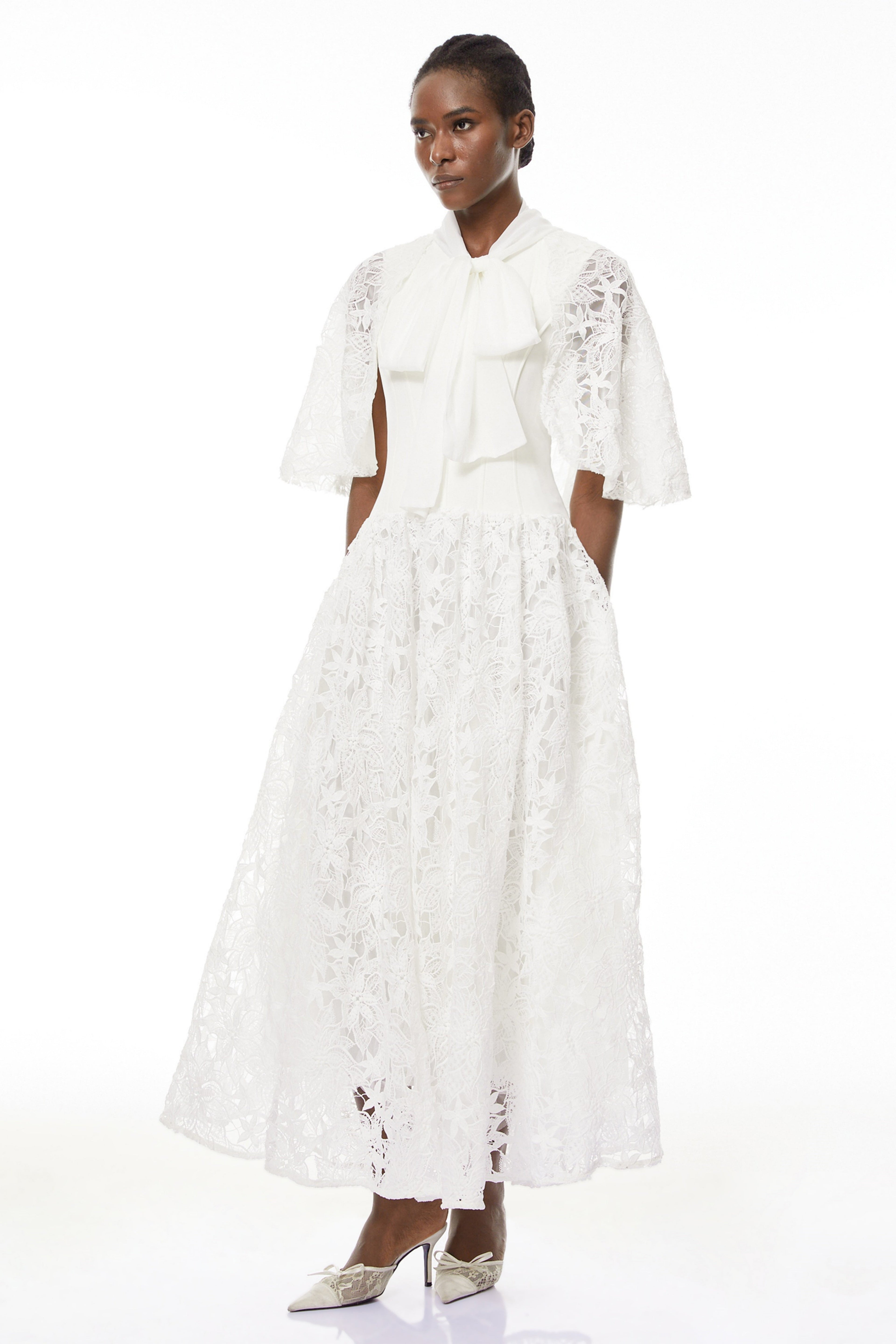 Vestido largo blanco con encaje floral y lazo en el cuello, de la marca MRMelbourne, para eventos elegantes.