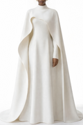 Mujer usando la capa larga Antonina blanca con mangas largas, vestido maxi de MRNewyork, en un entorno elegante y sofisticado.