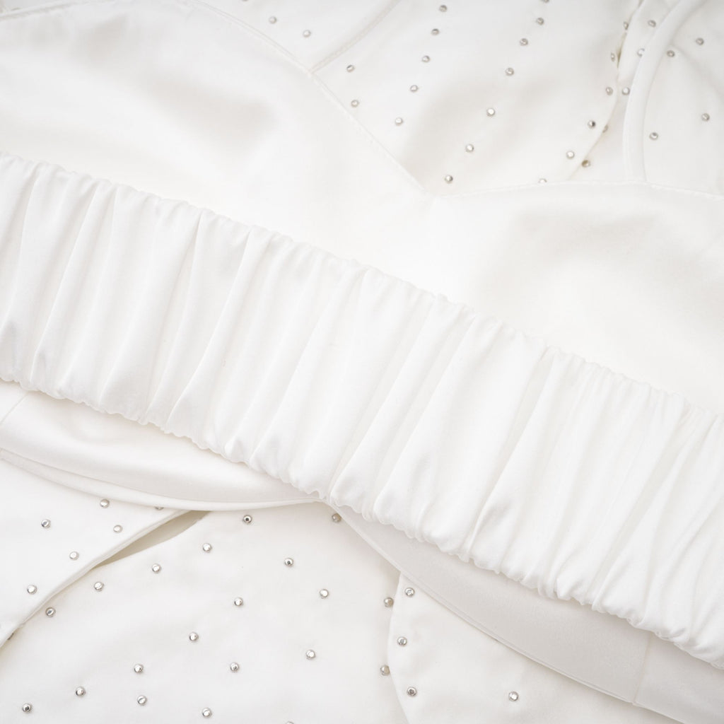 Camisa Maëlle con detalles de perlas falsas, moderna y elegante, en color neutro, diseñada para un estilo sofisticado y de moda.