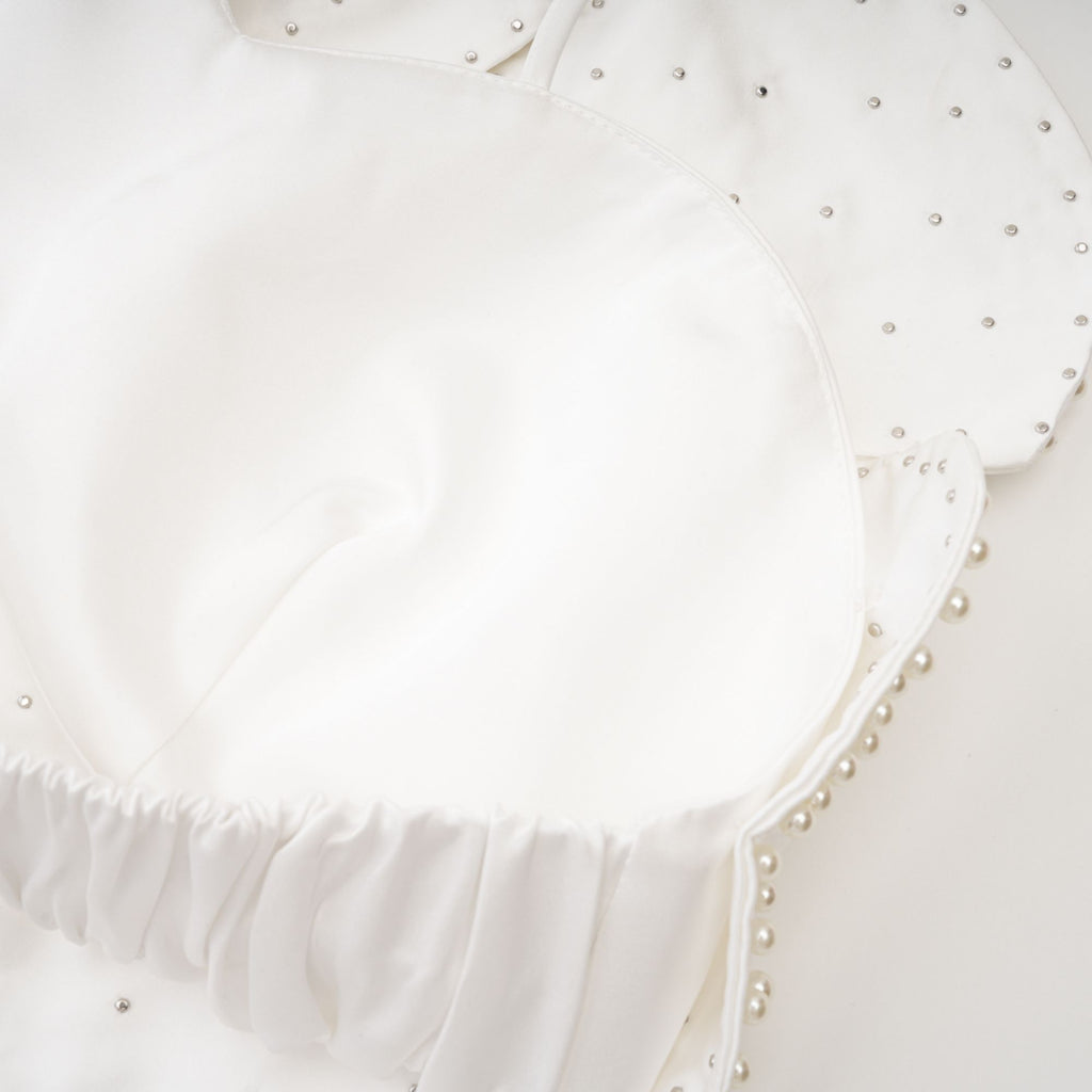 Blusa Maëlle con adornos de perlas falsas, de estilo elegante y moderna, en color neutro.