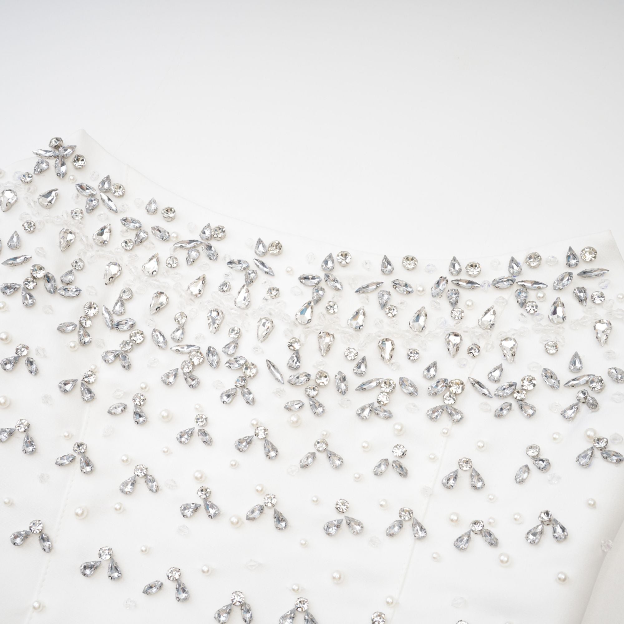 Vestido mini blanco Melisande con decoraciones elegantes y detalles brillantes, de estilo sofisticado y moderno.