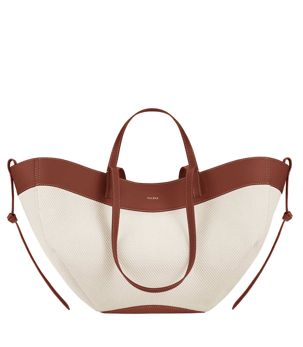 Bolso polipiel trenzado en color coñac de la marca Polène, vista frontal del bolso con asa y detalles de costura.